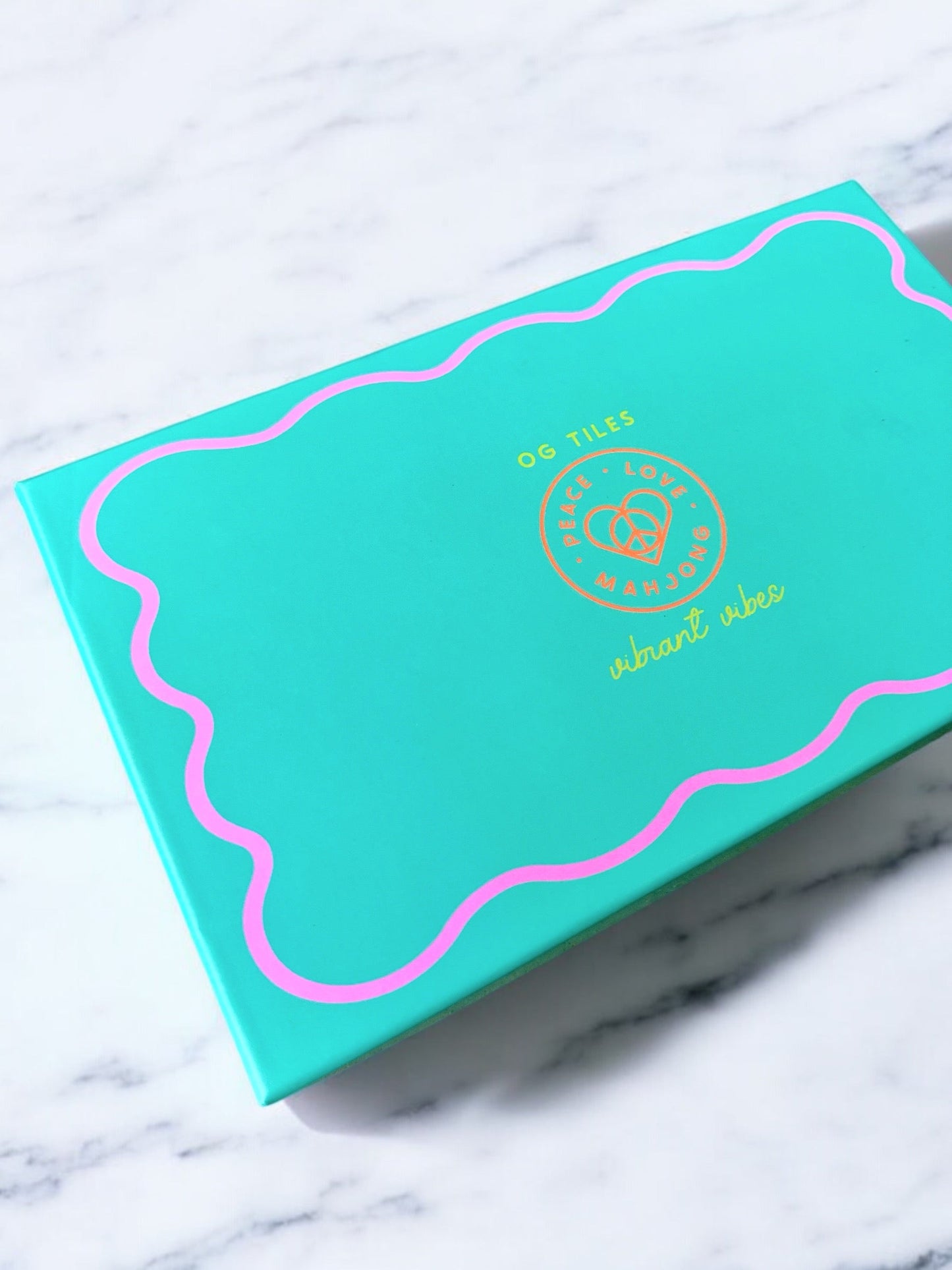 Vibrant Vibes Mahjong Set packaging on marble surface.