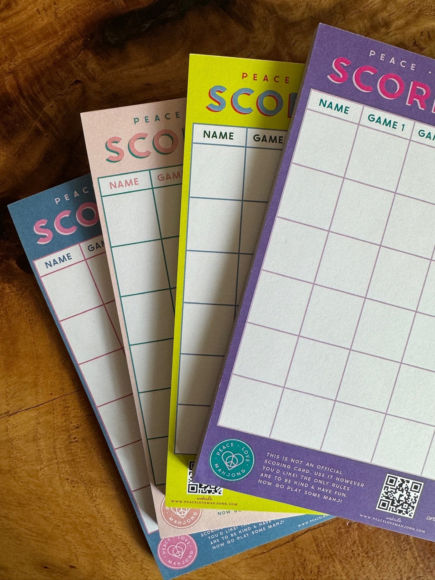 Mahjong Scoring Notepad with colorful sheets on a wooden surface, size 5x7, 50 sheets per notepad.