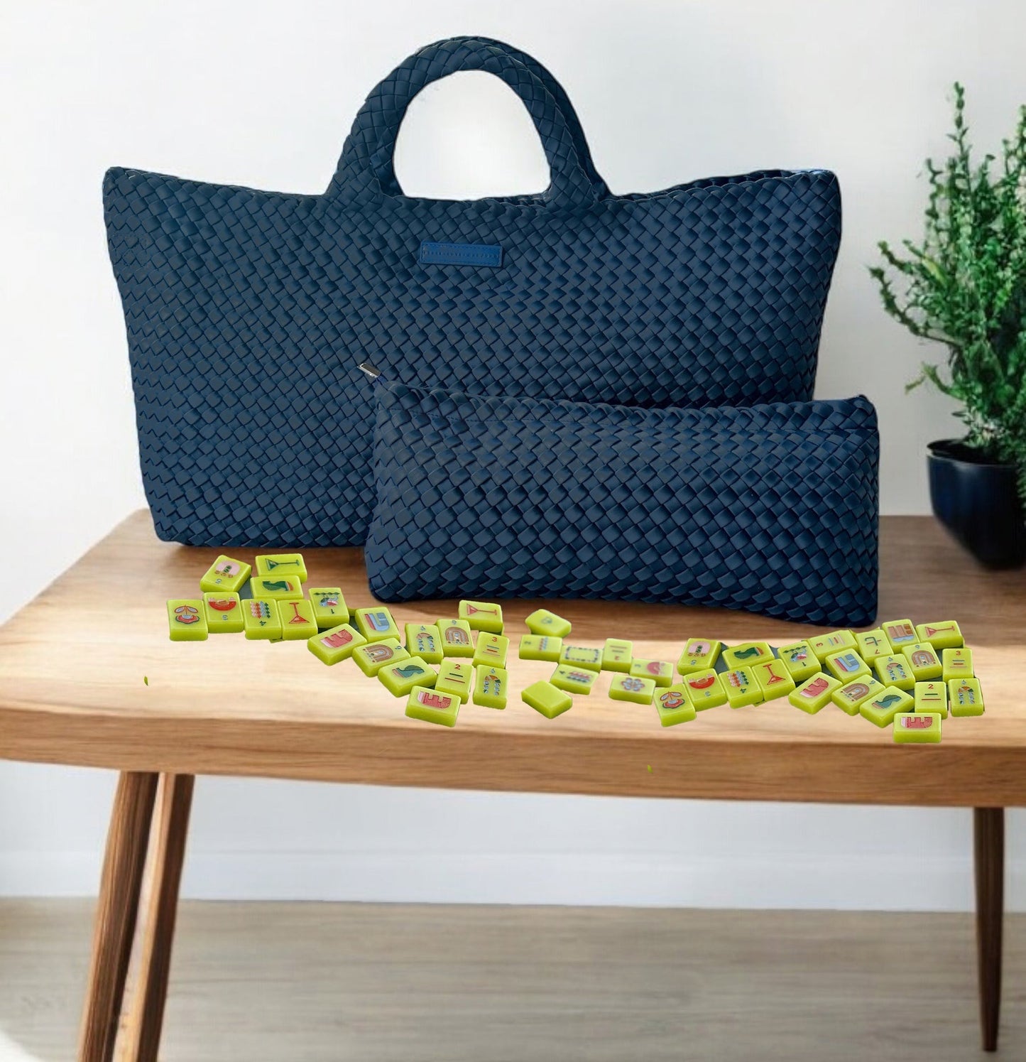 Woven Mahjong Carryall in navy with matching pouch and mahjong tiles on a wooden table.