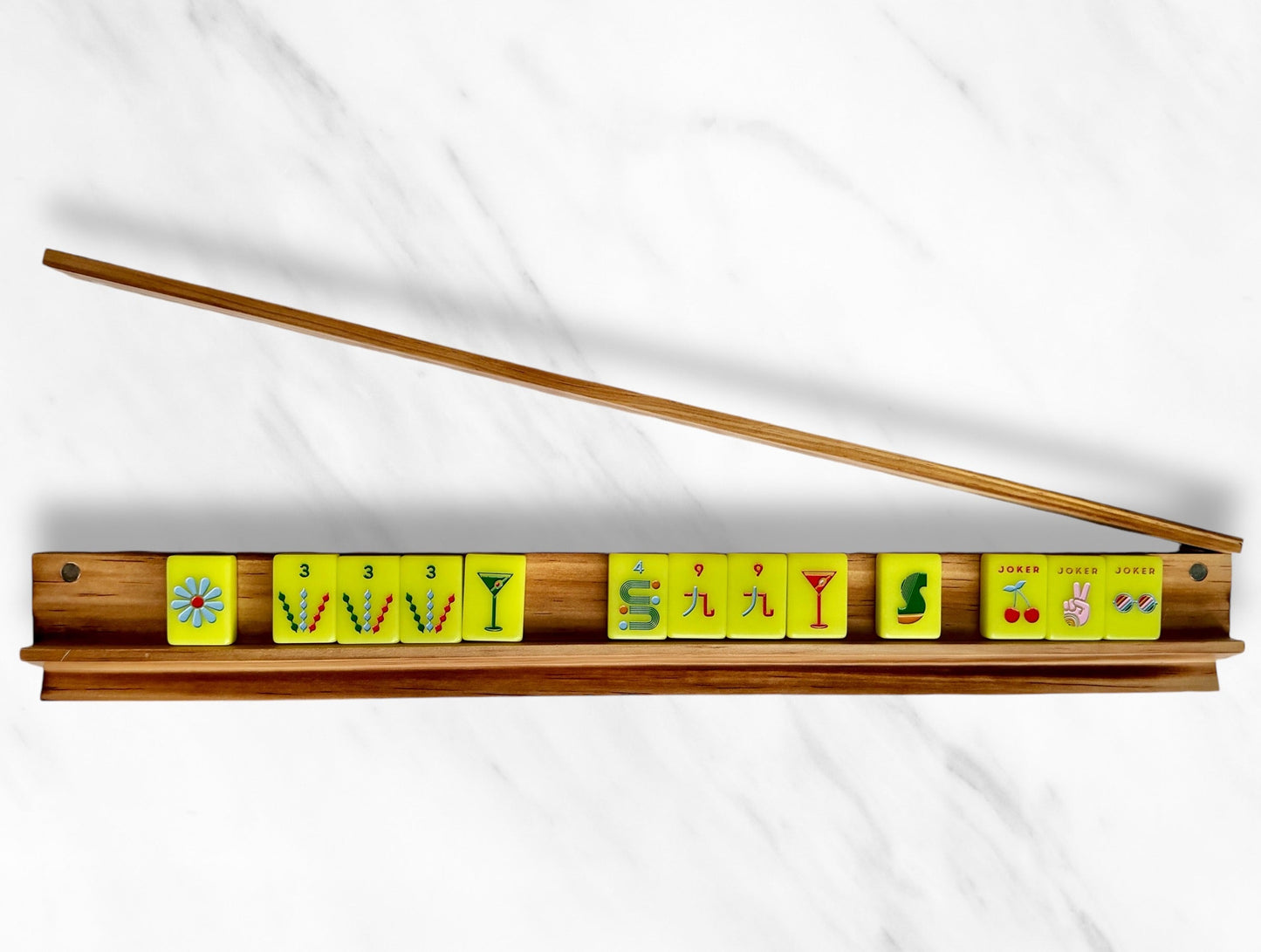 Mahjong racks and pushers set with colorful tiles on a sleek wooden rack.