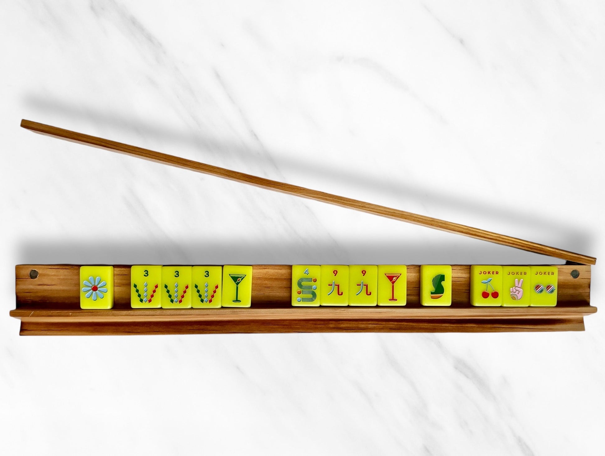 Mahjong racks and pushers set with colorful tiles on a sleek wooden rack.