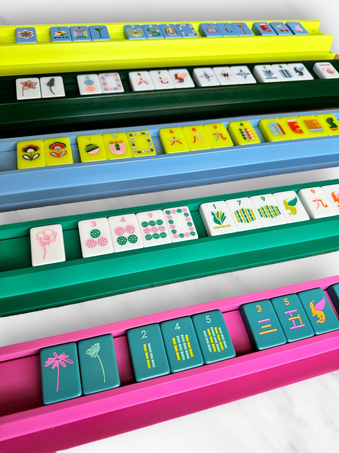 Colorful Mahjong racks and pushers set with tiles.